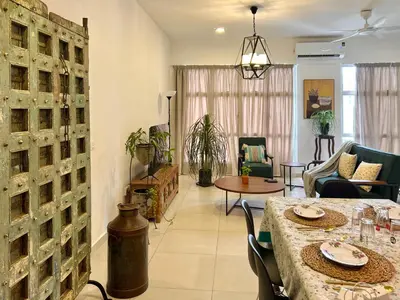 a living room with a table and chairs at 3 bedroom apt L26 at kl sentral with city view in Kuala Lumpur