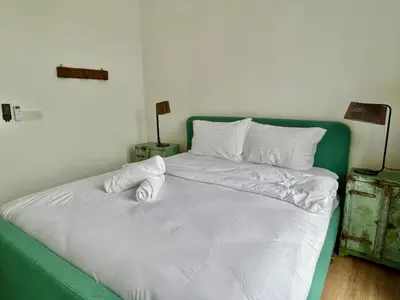 a green and white bed with white sheets and pillows at 3 bedroom apt L26 at kl sentral with city view in Kuala Lumpur