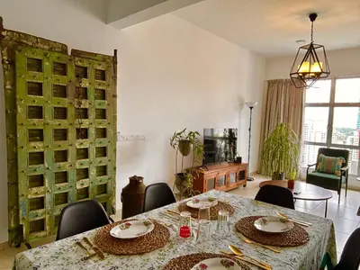 a dining room with a table and chairs at 3 bedroom apt L26 at kl sentral with city view in Kuala Lumpur