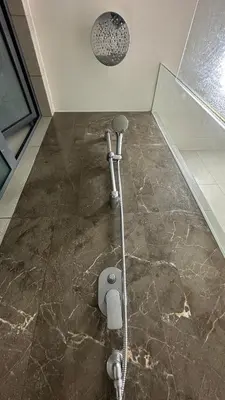 a shower in a bathroom with a stone floor at Datum Jelatek Superb Suite KL By LH in Kuala Lumpur