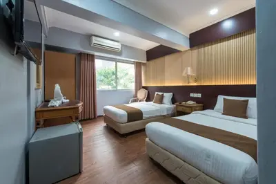 a hotel room with two beds and a television at Hotel grand orchard in Kuala Lumpur