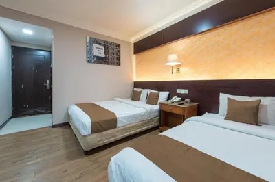 a hotel room with two beds and a bathroom at Hotel grand orchard in Kuala Lumpur