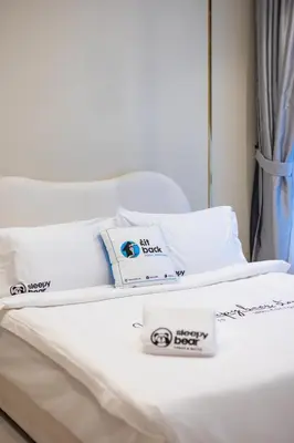 a bed with white sheets and pillows on it at Novo Ampang KL near Gleneagles by Sleepy Bear in Kuala Lumpur