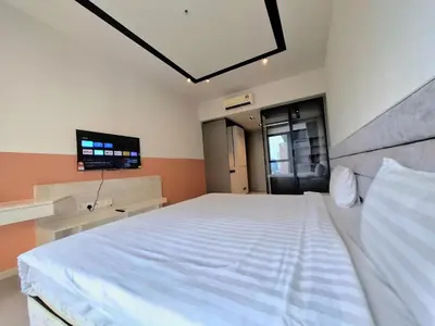 a bedroom with a large white bed and a flat screen tv at EXPRESSIONZ DESIGNER SUITES Host By AURORA PREMIUM STAY in Kuala Lumpur
