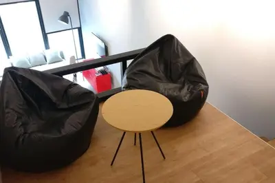 two black bean bag chairs and a wooden table at 3min Bangsar LRT-1 Station to KL Sentral-SuperView in Kuala Lumpur