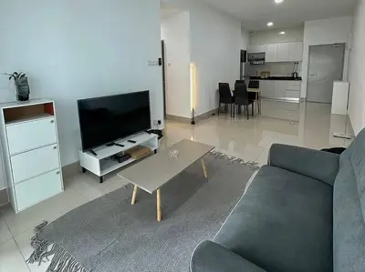 a living room with a couch and a tv and a table at Rc Residences in Kuala Lumpur