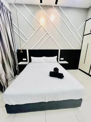 a bedroom with a bed with a black hat on it at The Luxe Stay Chamber KL in Kuala Lumpur