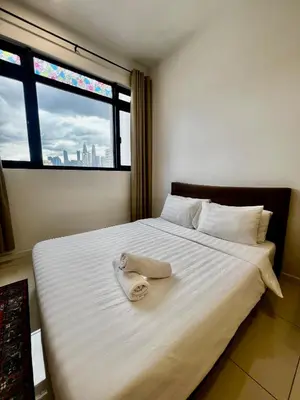 a bed with a towel on it with a window at The Luxe Stay Chamber KL in Kuala Lumpur