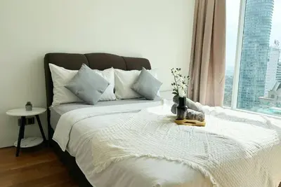 a bedroom with a white bed with a window at Premium Living Sky Suites - Twin Towers KLCC 2-min walk in Kuala Lumpur
