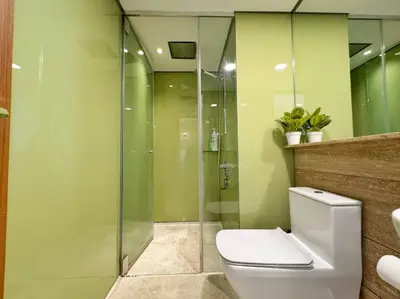 a bathroom with a toilet and a glass shower at Premium Living Sky Suites - Twin Towers KLCC 2-min walk in Kuala Lumpur