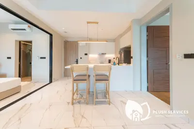 a kitchen and living room with a bar with stools at Alfa Bangsar by Plush in Kuala Lumpur