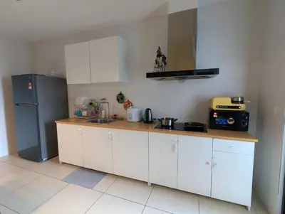 a kitchen with white cabinets and a black refrigerator at Reizz Residence Majesty Suite in Kuala Lumpur