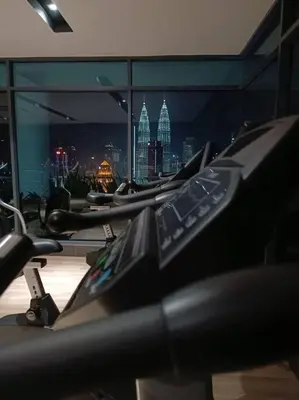 a row of exercise bikes in a gym with a city skyline at COL 23a8B Modern KLCC View Studio in Kuala Lumpur