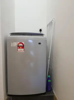 a white refrigerator sitting next to a white wall at COL 23a8B Modern KLCC View Studio in Kuala Lumpur