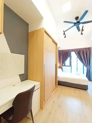 a room with a desk and a bed with a ceiling fan at COL 23a8B Modern KLCC View Studio in Kuala Lumpur
