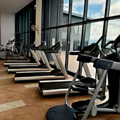 a row of exercise machines in a gym with windows at 3 Towers Jalan Ampang KL in Kuala Lumpur