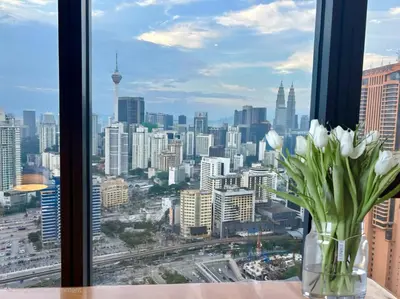 a vase of white flowers sitting on a table in a window at 3 Towers Jalan Ampang KL in Kuala Lumpur
