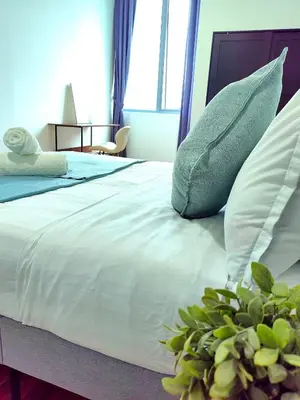 a bedroom with a white bed with pillows and a plant at Hi\u8212\u9002\u5927\u5e8a\u623f klcc\u65c1 \u8f7b\u8f68\u65c1 \u65e0\u8fb9\u6e38\u6cf3\u6c60 in Kuala Lumpur