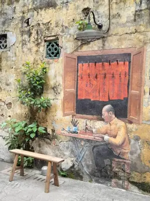 a painting of a man sitting at a table on a wall at Cozy Idaman Robertson Suite Balcony in Kuala Lumpur