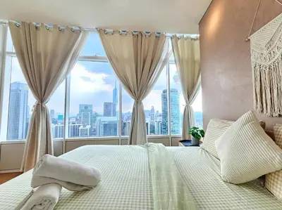 a bedroom with a bed and a large window at The Sky Residence KLCC by AsianHost in Kuala Lumpur
