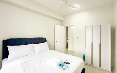 a bedroom with a white bed with a blue headboard at Vista Sentul Residences by Airhost in Kuala Lumpur