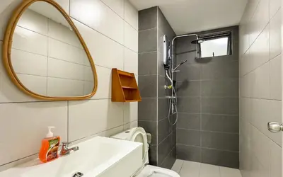 a bathroom with a toilet and a sink and a mirror at Vista Sentul Residences by Airhost in Kuala Lumpur
