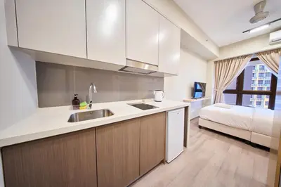 a kitchen with a sink and a bed in a room at Agile Bukit Bintang KLCC by Plush in Kuala Lumpur