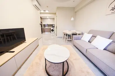 a living room with a couch and a tv and a table at Agile Bukit Bintang KLCC by Plush in Kuala Lumpur