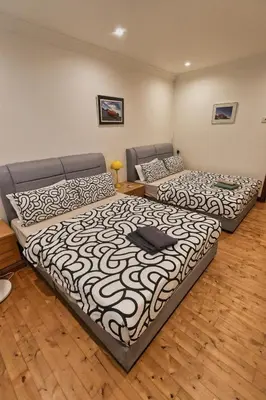 two beds in a room with wooden floors at 1Min Pavilion Bukit Bintang KLCC Wisma Cosway in Kuala Lumpur