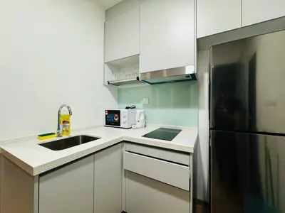 a kitchen with white cabinets and a stainless steel refrigerator at Riveria City By Dream stay in Kuala Lumpur
