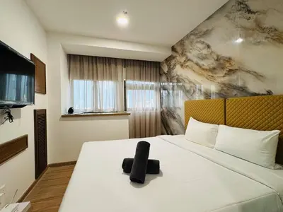 a bedroom with a bed with a black object on it at Riveria City By Dream stay in Kuala Lumpur
