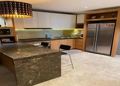 a kitchen with a refrigerator and a counter with chairs at YippieeAnggunHomestay in Kuala Lumpur