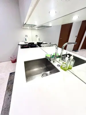 a kitchen counter with a sink and a mirror at Sky Suites KLCC by NADIA in Kuala Lumpur