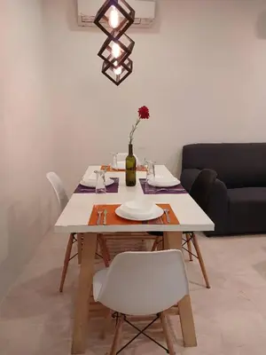 a dining room table with white chairs and a couch at VORTEX SUITS KLCC by MMHB in Kuala Lumpur