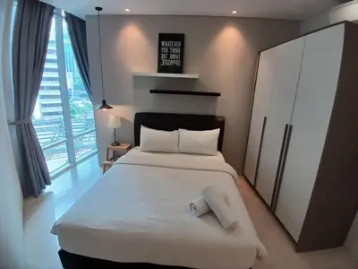 a bedroom with a white bed with a towel on it at VORTEX SUITS KLCC by MMHB in Kuala Lumpur