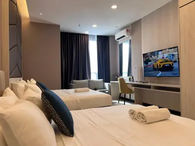 a hotel room with two beds and a flat screen tv at Societe Hartamas Kuala Lumpur in Kuala Lumpur