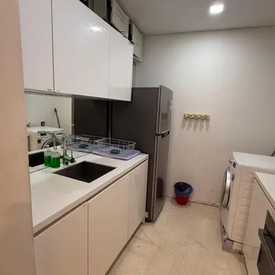 a kitchen with white cabinets and a stainless steel refrigerator at Vortex Suites Klcc Area in Kuala Lumpur