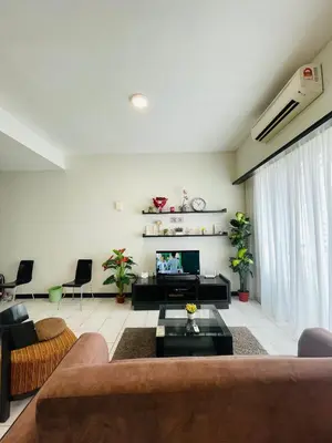 a living room with a couch and a tv at Seri Bukit Ceylon Suites Bukit Bintang in Kuala Lumpur