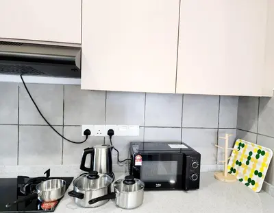 a kitchen counter with a microwave and pots and pans at Cheras MRT KLCC View Home by DefineSuite in Kuala Lumpur