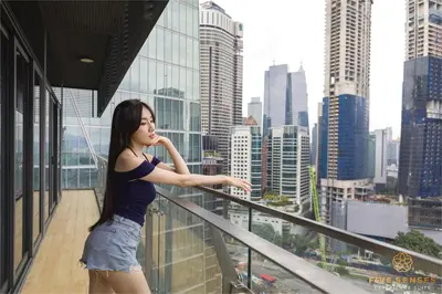 a woman standing on a balcony looking at the city at Dorsett Kuala Lumpur, Five Senses in Kuala Lumpur