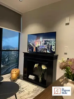 a living room with a fireplace with a flat screen tv at KLCC Scarletz Executive Suite by ThePigeonHole in Kuala Lumpur