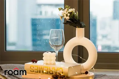a table with a cake and a vase with flowers at The Riv, Riveria City KL Sentral in Kuala Lumpur