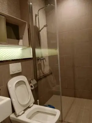 a bathroom with a toilet and a glass shower at TS Hotel Service Residence Kuala Lumpur in Kuala Lumpur