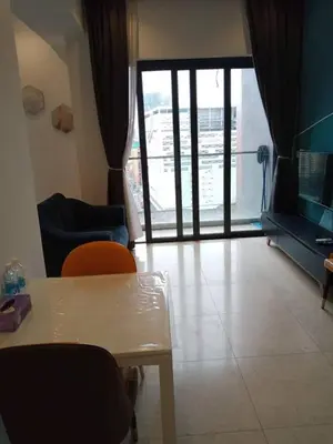 a living room with a table and chairs and a sliding glass door at TS Hotel Service Residence Kuala Lumpur in Kuala Lumpur
