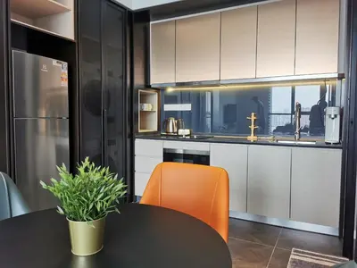 a kitchen with an orange chair and a table at Scarletz Suites KLCC by De Harlequins Suite in Kuala Lumpur