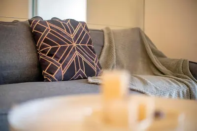 a couch with a pillow and a table at Carlton, Chelsea at Plaza Damas 3, Sri Hartamas Kuala Lumpur in Kuala Lumpur