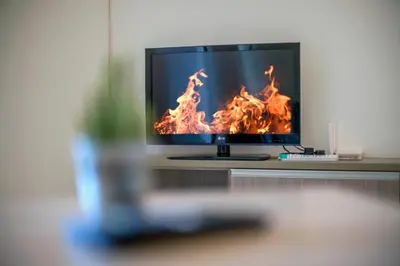 a television sitting on a table with flames on it at Carlton, Chelsea at Plaza Damas 3, Sri Hartamas Kuala Lumpur in Kuala Lumpur