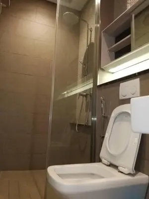 a bathroom with a white toilet and a shower at Lotus Suite Scarletz KLCC in Kuala Lumpur