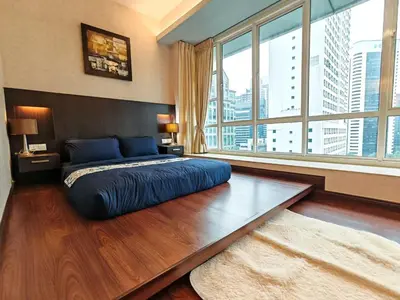 a bedroom with a large bed with a large window at Parkview Serviced Apartment in Kuala Lumpur