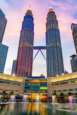 two tall skyscrapers in a city with a fountain at Parkview Serviced Apartment in Kuala Lumpur